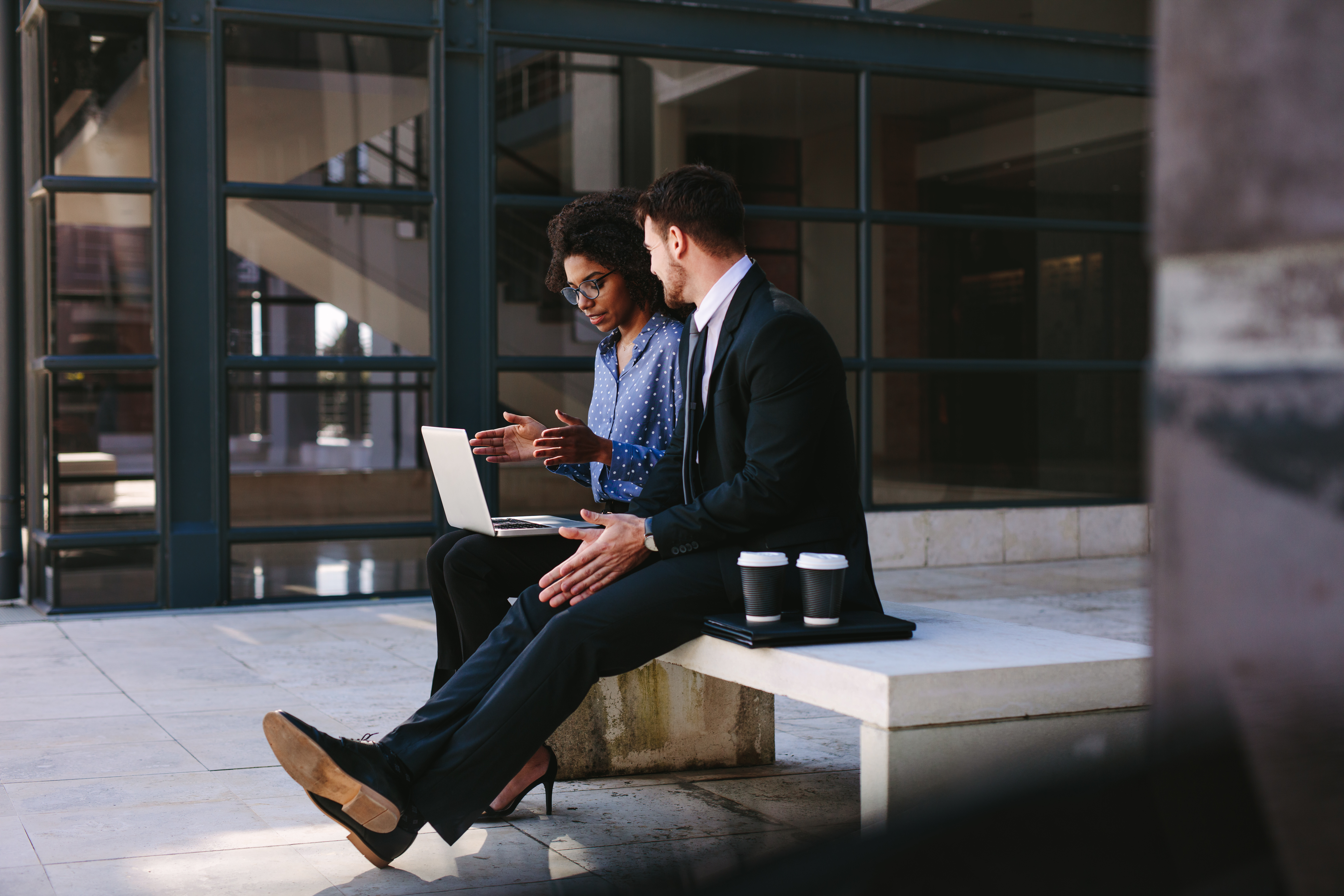 Two,Business,People,Sitting,On,A,Bench,In,Modern,Office To, Forretninger, Folk, Sittende, På, A, Benk, I, Moderne, Kontor
